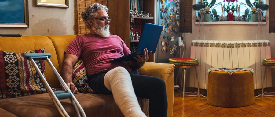 a man with leg injuries sitting and reading a book