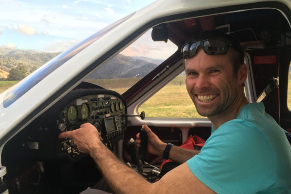 Mathew seated in the cockpit of a small plane, showcasing a joyful moment in aviation.