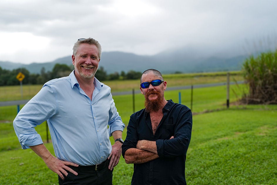 Maurice Blackburn lawyer Alan with his client Tim, standing on the field, smiling