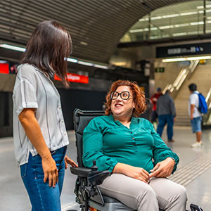 A woman talking to another woman sitting on the wheelchair