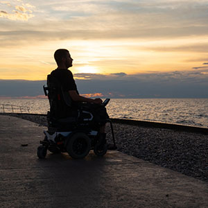 A man in wheelchair by the beach